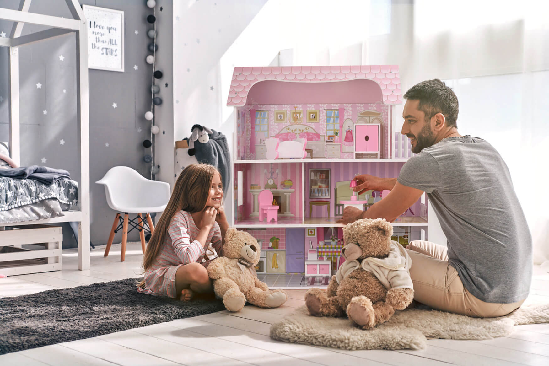 Ein herzerwärmendes Lifestyle-Foto zeigt ein rosa Puppenhaus, während ein Mädchen freudig mit ihrem Vater spielt. Unsere Produktfotografie fängt die Spielfreude und die emotionale Bindung dieses besonderen Moments ein, der die Fantasie und das Miteinander fördert.