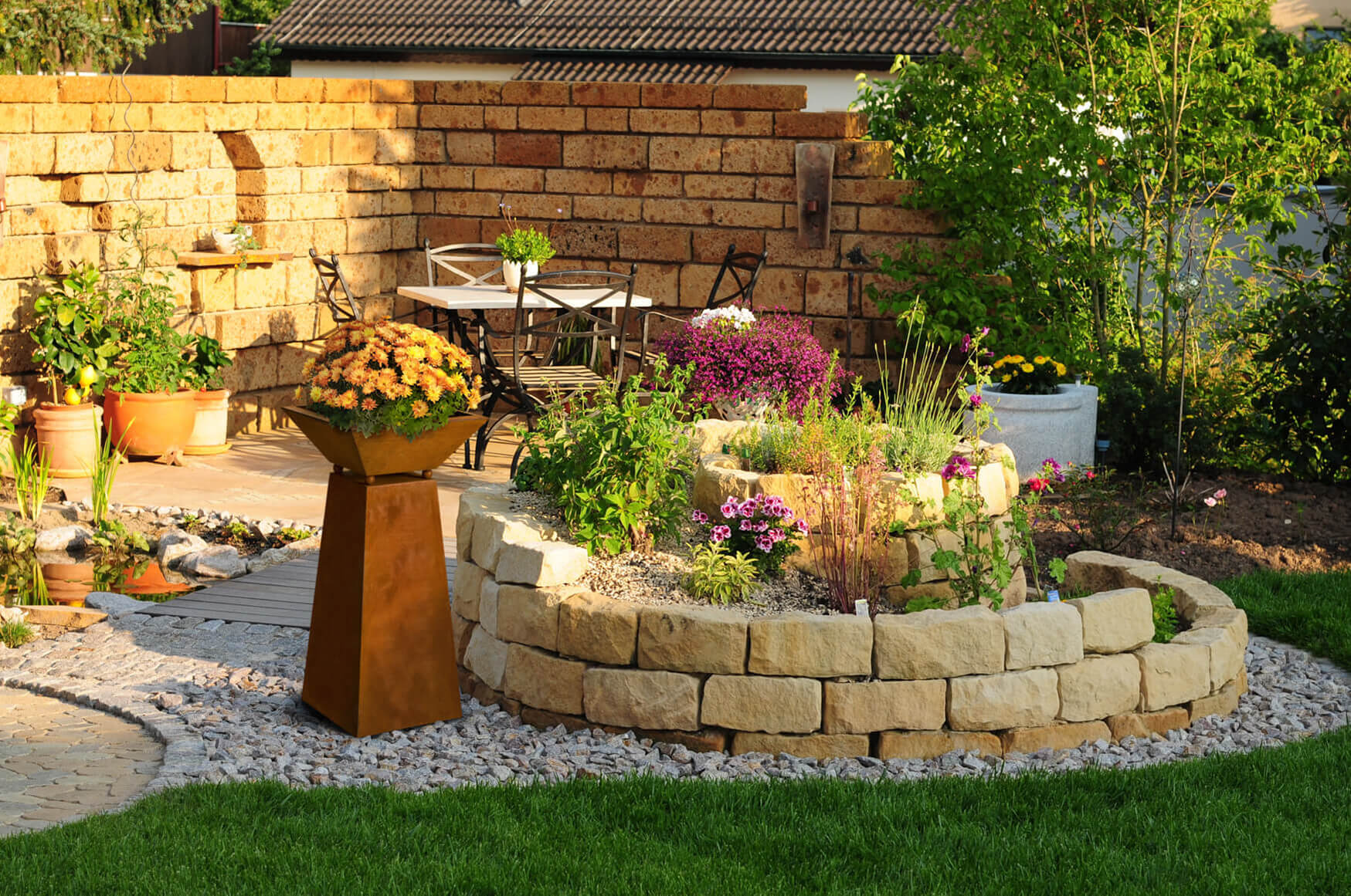 Ein bezauberndes Lifestyle-Foto zeigt eine rostige Deko-Säule im Steingarten, liebevoll mit blühenden Blumen bepflanzt. Unsere Produktfotografie fängt die natürliche Schönheit und den rustikalen Charme dieser Garteninstallation ein, die eine harmonische Verbindung zwischen Natur und Kunst schafft.