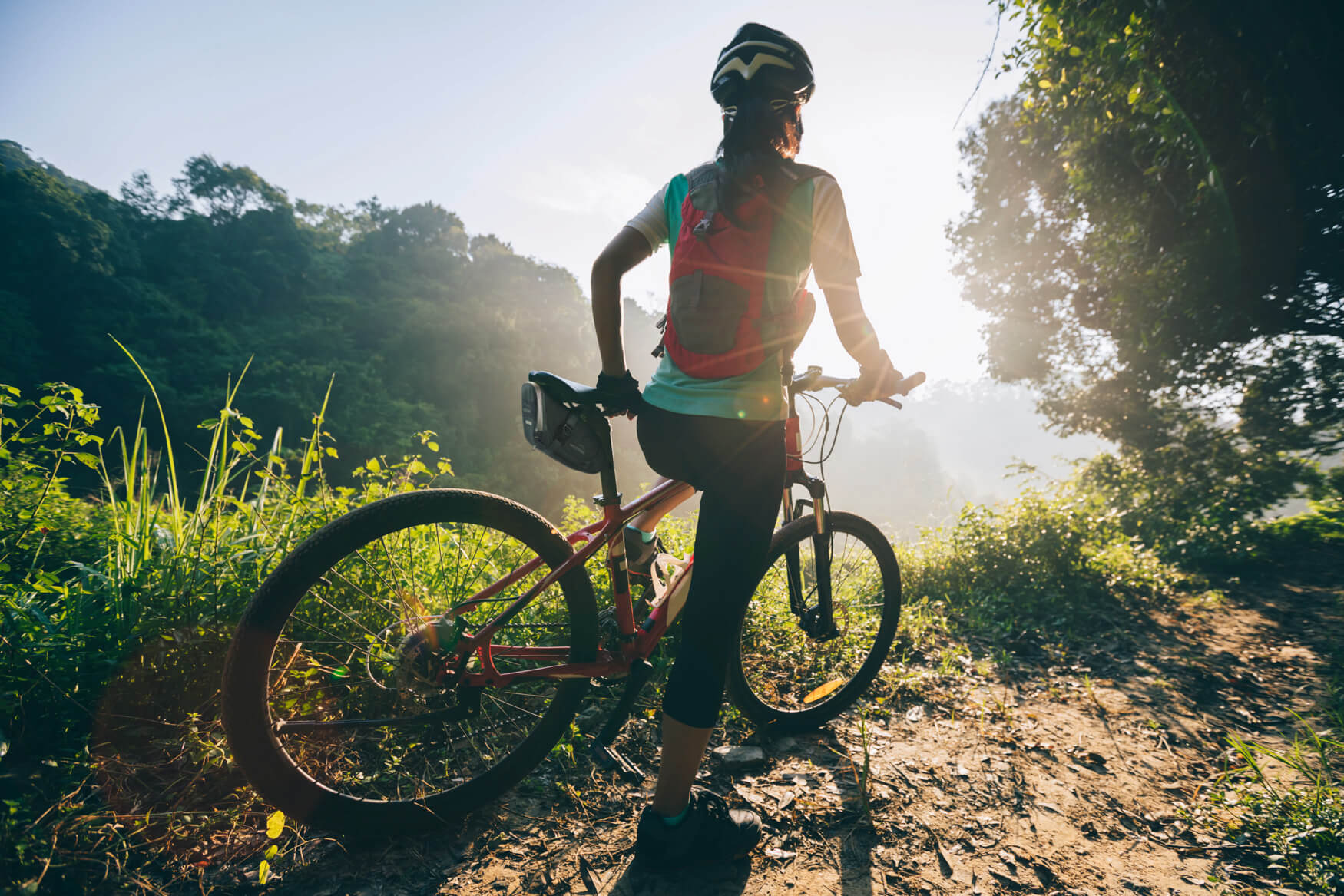 Mountainbiker mit Hinterradtasche auf einem Feldweg.