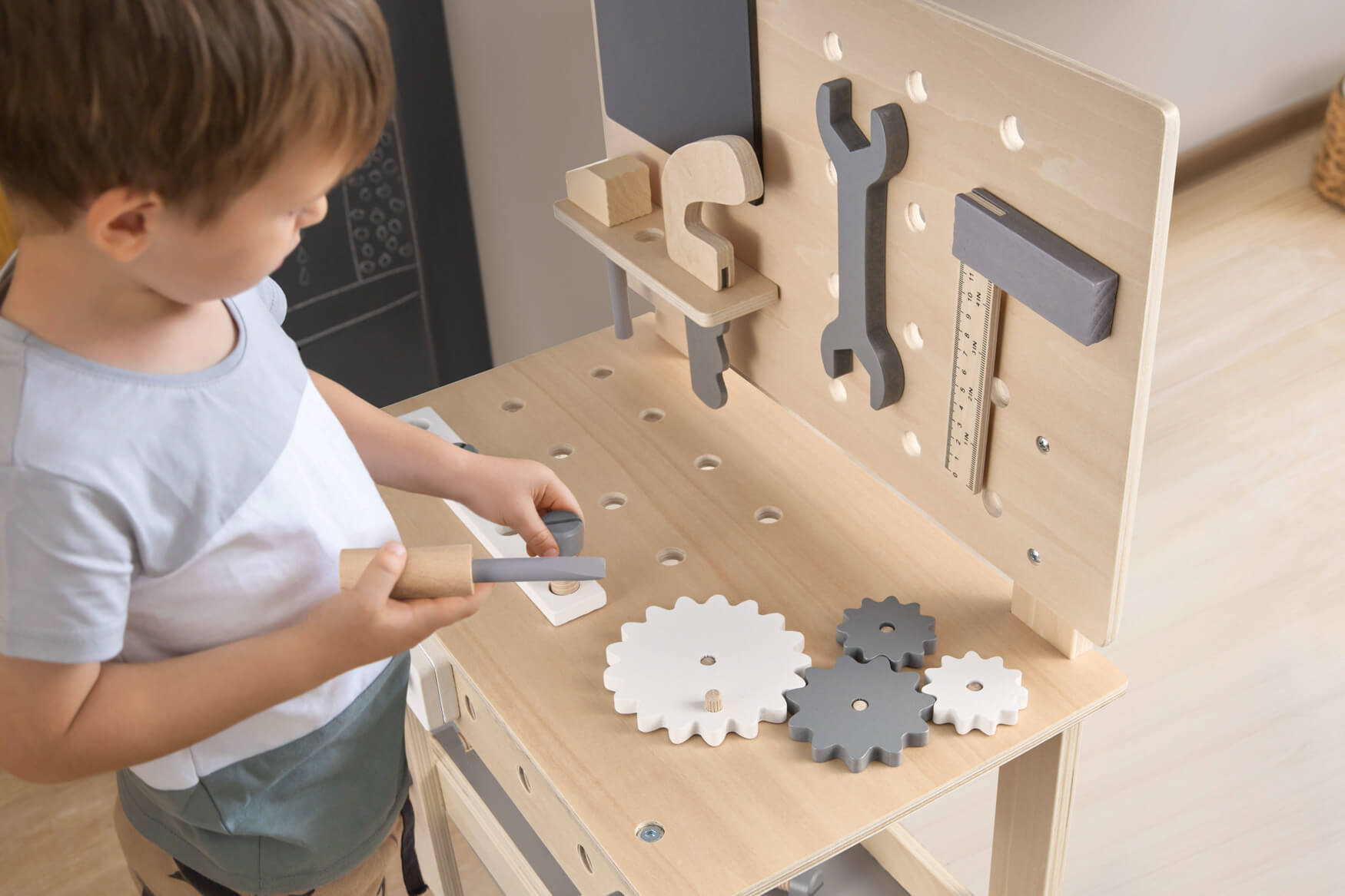 Ein junger Handwerker in Aktion an seiner Holzwerkbank. Mit einem Schraubenzieher bewaffnet, erkundet er neugierig die Welt des Handwerks. Ein inspirierendes Bild, das die Fantasie anregt und potenzielle Kunden dazu ermutigt, sich vorzustellen, wie ihr Produkt in Gebrauch ist